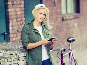 Middle aged woman using mobile device to browse nearby new homes for sale